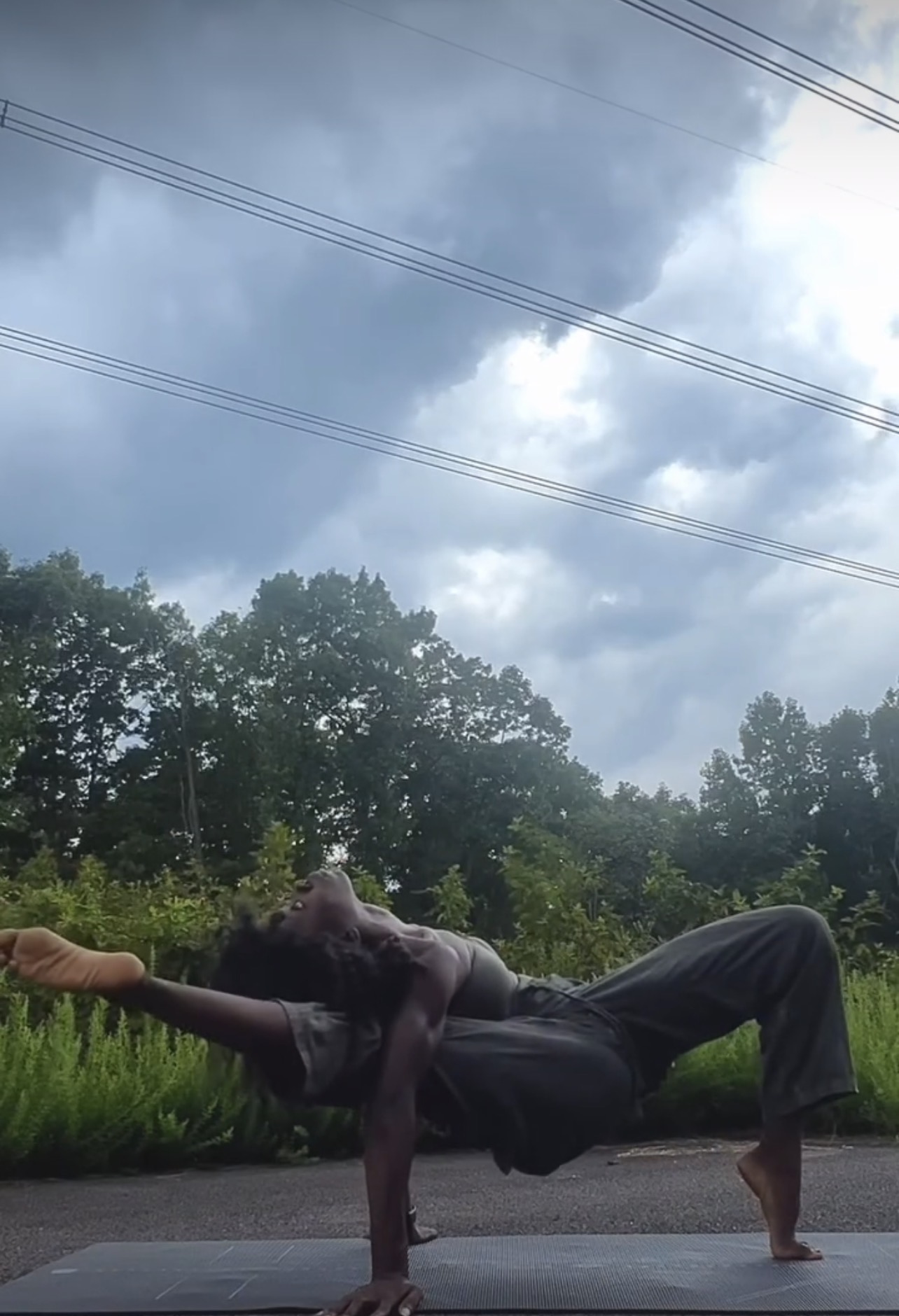Dalvida in a one-arm balance outdoors